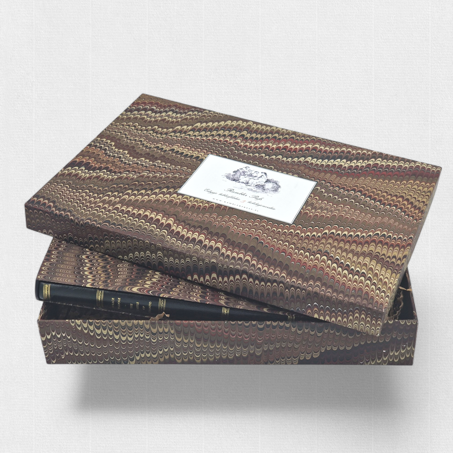 A luxurious 2022 Rambler Press edition of The Castle of Otranto by Horace Walpole, limited to 25 hand-numbered copies. The octavo book, printed on Century Laid cotton paper with watermarks in Monotype Bell typeface, features a half-leather binding with hand-marbled paper sides, gilded edges, and a custom slipcase. The cover evokes the eerie Gothic atmosphere of the 1764 novel, with shadowy castle motifs and intricate detailing, reflecting its status as the cornerstone of the Gothic genre.
