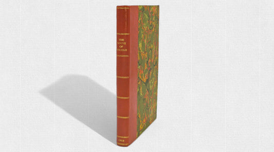 First edition of “The House of Angelo” (1953) by J.D. Aylward, hand-bound in half-leather with marbled boards, standing upright on a light textured background.
